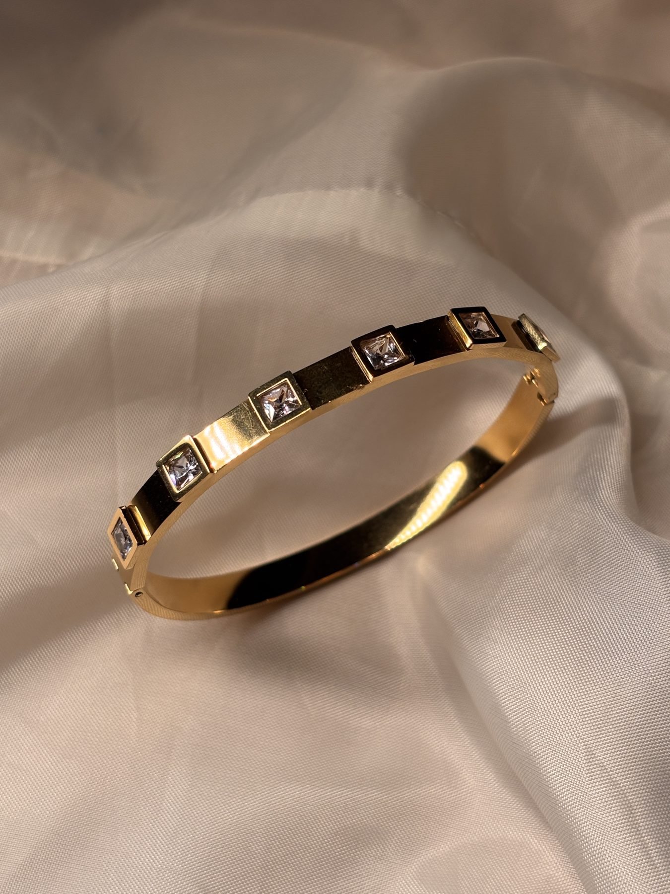Angled view of the Cinderella Bracelet showing its polished gold finish