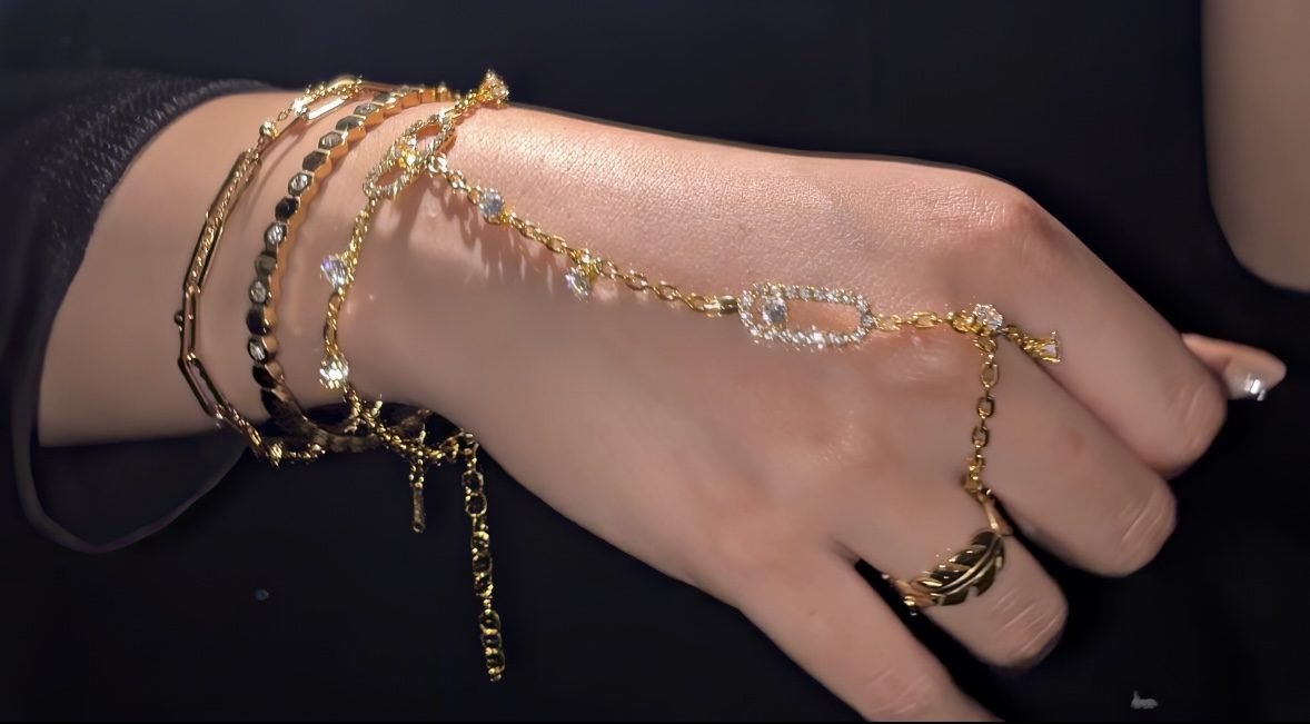 Gold hand chain worn across the back of the hand