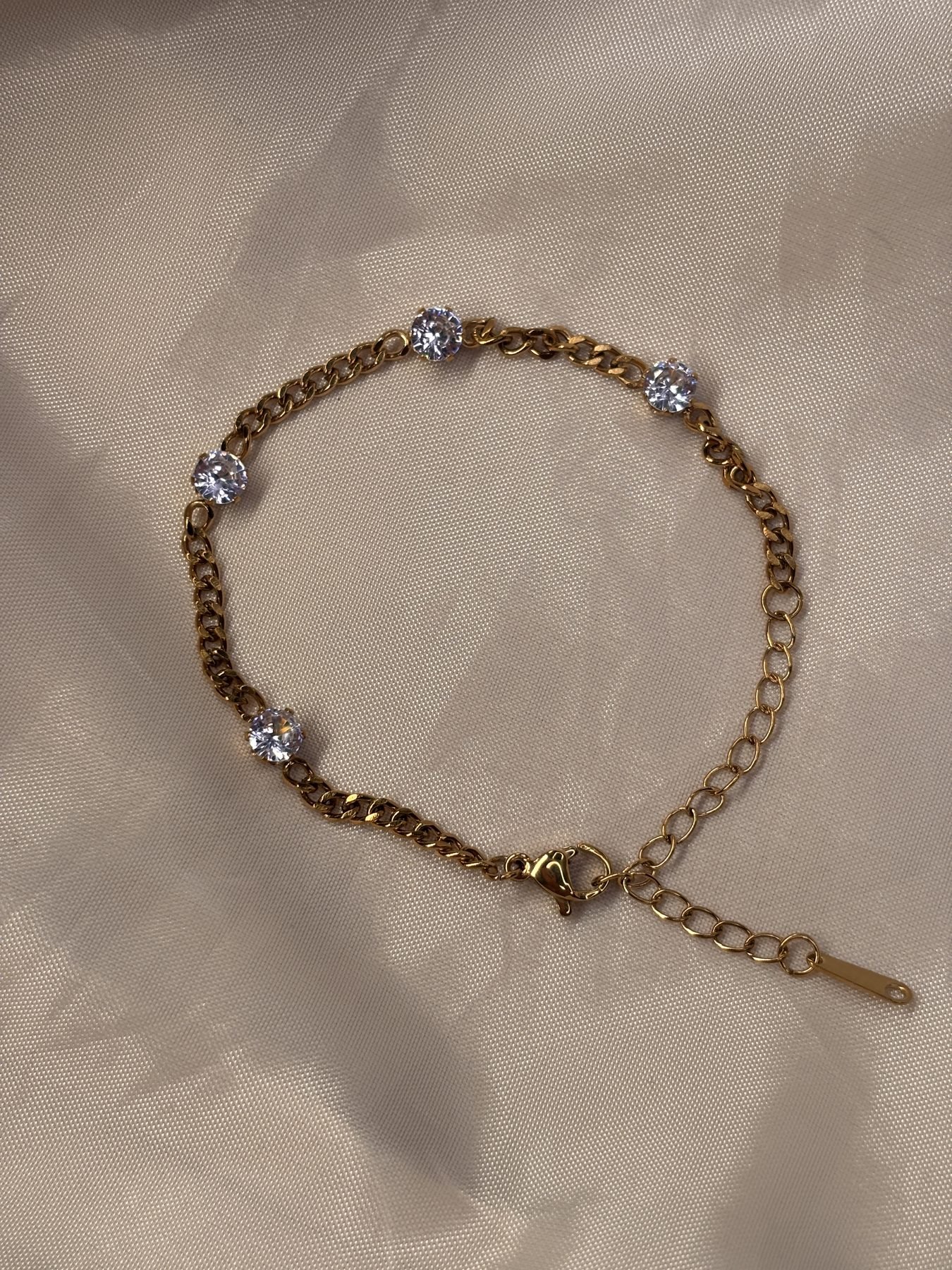 The Minimal Bracelet on cream silk: a fine gold chain with spaced solitaire stones